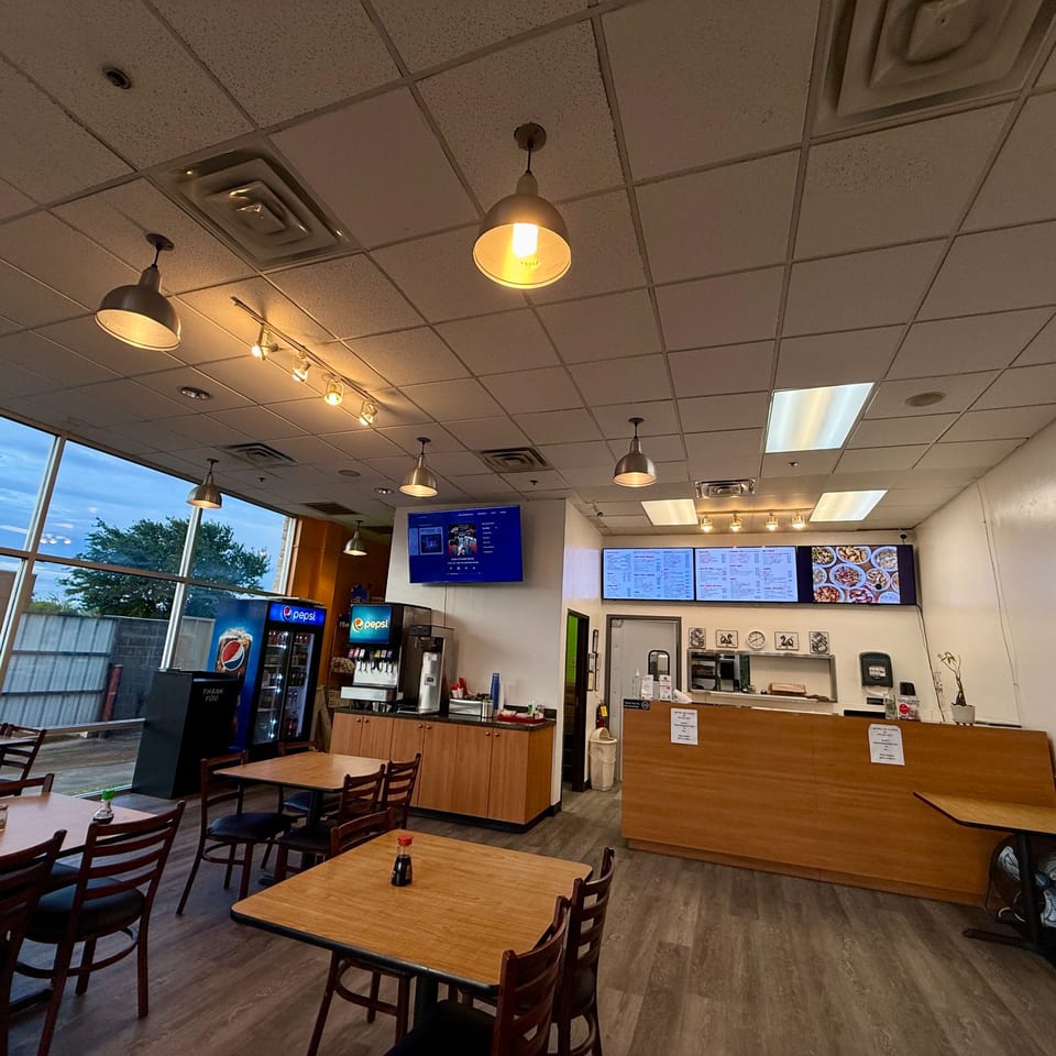 Interior of Red Panda Wok & Grill, showing dining tables, a counter, and menu screens.